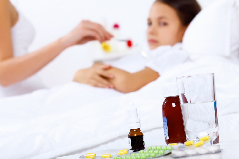 Little girl with illness at bed at home