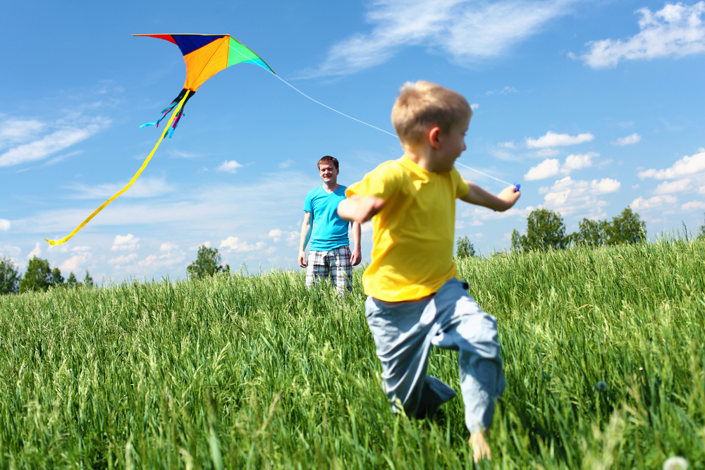 father with son in summer playing with kite